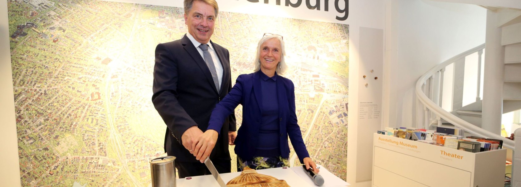 Oberb&uuml;rgermeister J&uuml;rgen Krogmann und OTM-Gesch&auml;ftsf&uuml;hrerin Silke Fennemann schneiden eine Lappan-Torte zur Er&ouml;ffnungsveranstaltung Oldenburg-Info im Lappan an. 