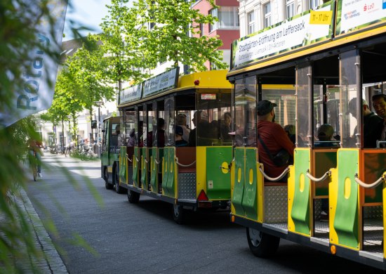 Die elektrisch betriebene Bimmelbahn (Stadtgärten-Raupe) auf einer Fahrt durch die Fußgängerzone am Eröffnungstag der Stadtgärten 2025.