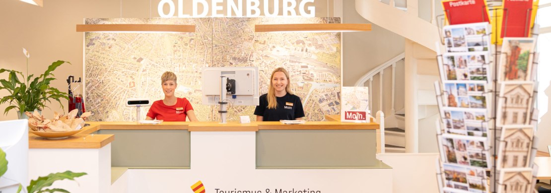 Zwei Mitarbeiterinnen stehen hinter dem Tresen in der Oldenburger Touristinfo