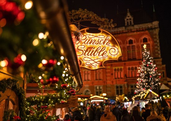 Punsch Stüble auf dem Oldenburger Weihnachtsmarkt mit Rathaus im Hintergrund.