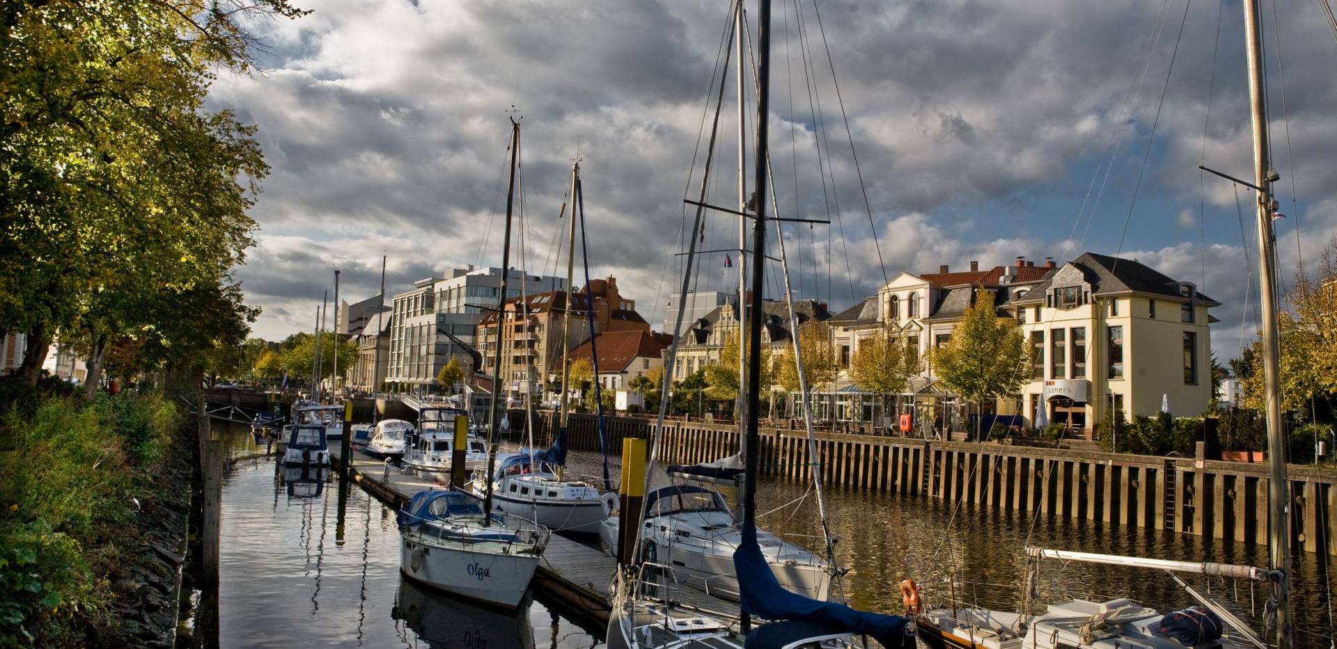 Blick auf den Stadthafen am Stau in Oldenburg mit Yacht- und Segelbooten im Vordergrund. 