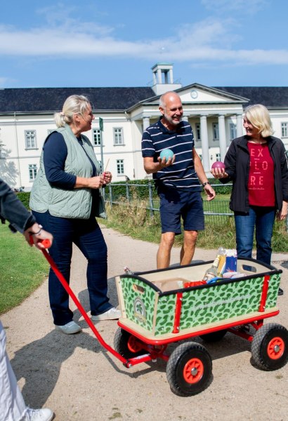 Teilnehmerinnen und Teilnehmer der Stadtführung lernen etwas über das Boßeln.