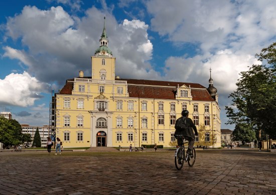 Blick auf das Oldenburger Schloss mit Schlossplatz und Radfahrer.