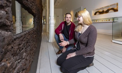 Zwei Jugendliche im Landesmuseum für Natur und Mensch in Oldenburg schauen sich eine Moorleiche an und diskutieren.