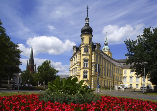 Blick auf das Oldenburger Schloss mit Blumenbeet im Vordergrund.