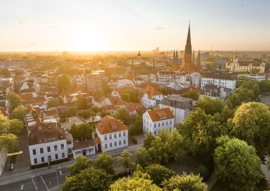 Luftblick auf die Innenstadt mit Schloss und St. Lamberti-Kirche im Hintergrund. 