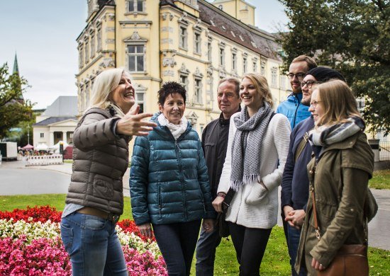 Eine kleine Gruppe mit einer Gästeführerin vor dem Oldenburger Schloss.
