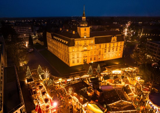 Luftblick auf den Oldenburger Weihnachtsmarkt auf dem Schlossplatz mit dem Oldenburger Schloss. 