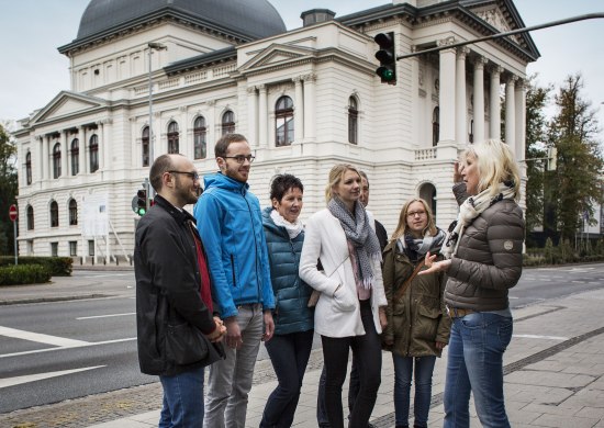 Eine Gruppe während einer Stadtführung vor dem Oldenburgischen Staatstheater. 