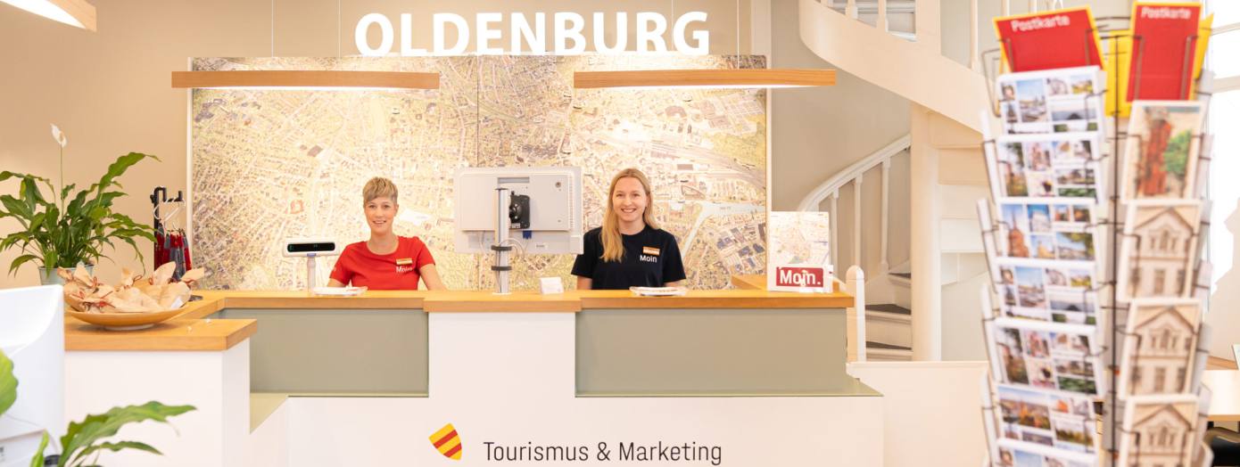 Zwei Mitarbeiterinnen stehen hinter dem Tresen in der Oldenburger Touristinfo